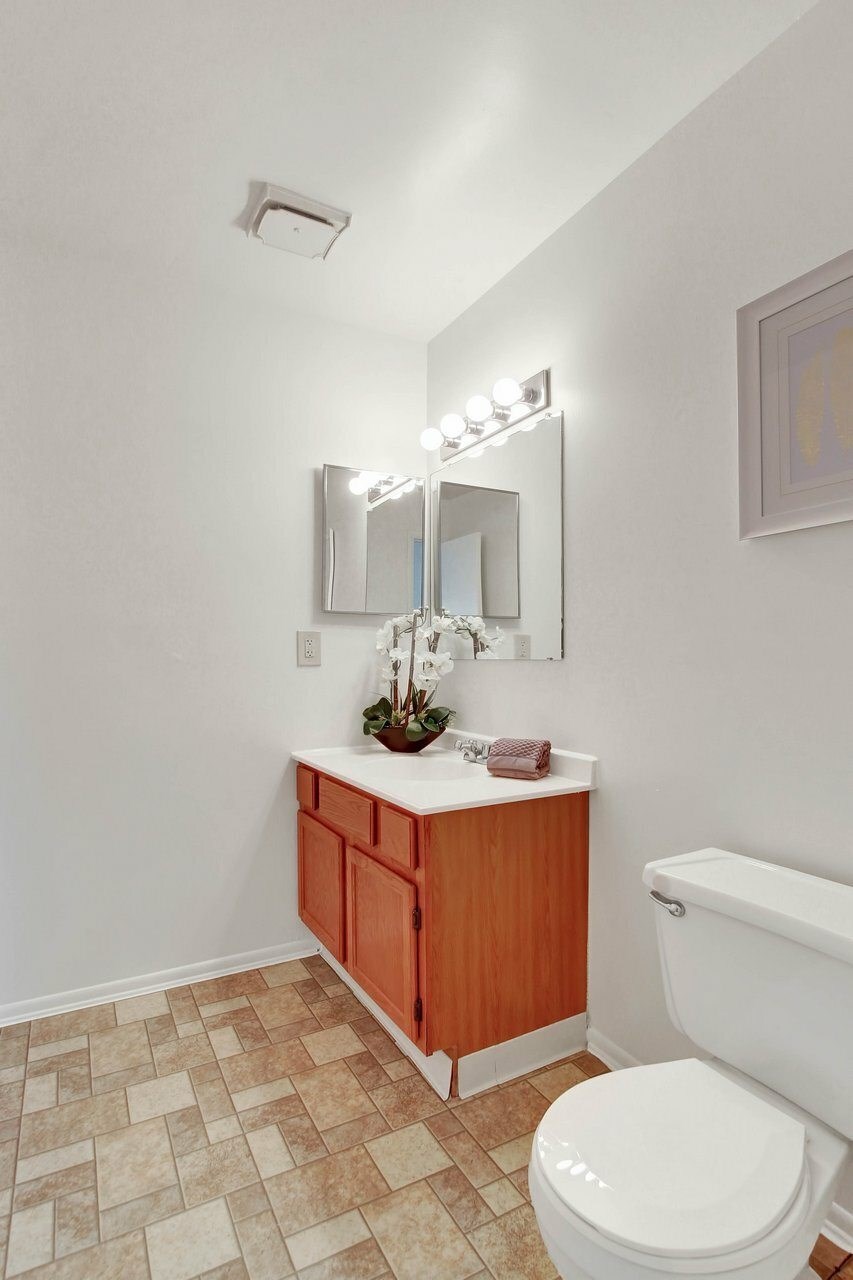 A bathroom with a white toilet and a wooden cabinet.
