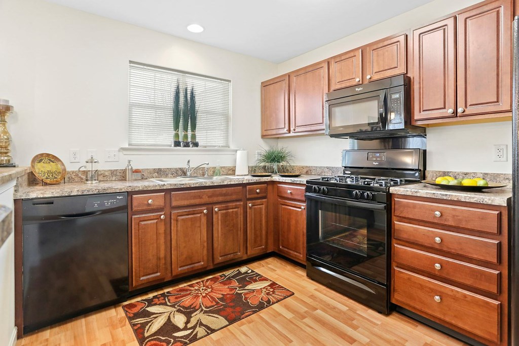 A kitchen with wooden cabinets and a black stove top oven.
