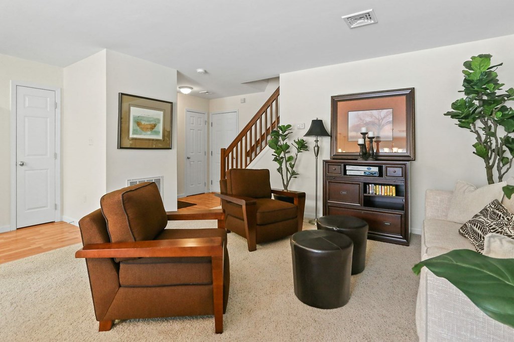 A living room with a brown chair and a white couch.