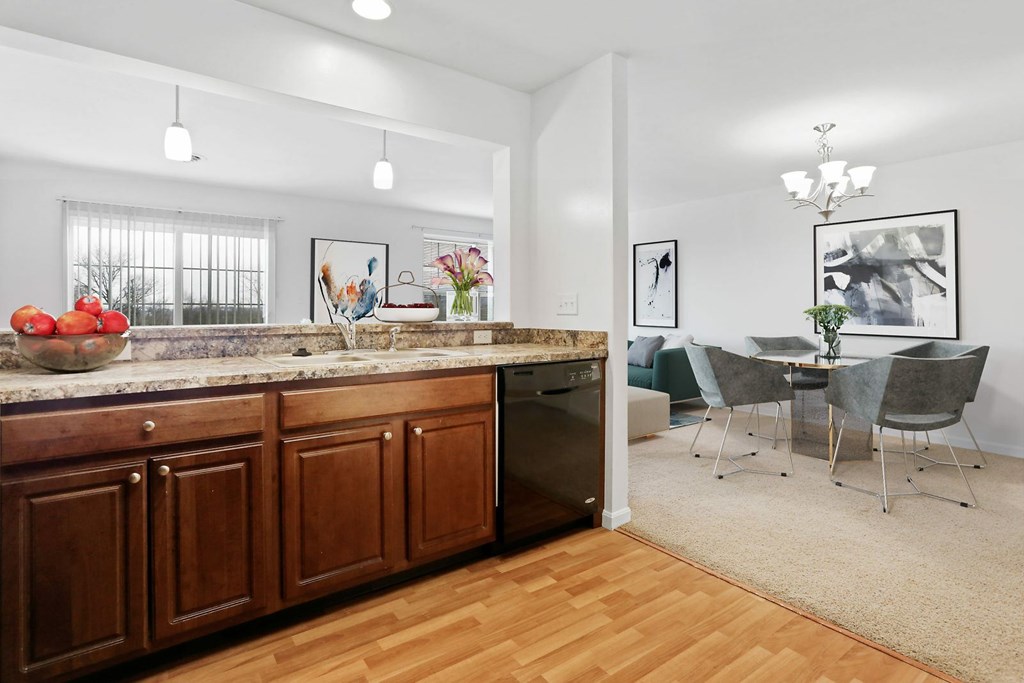 A kitchen with wooden cabinets and a dining table with chairs.