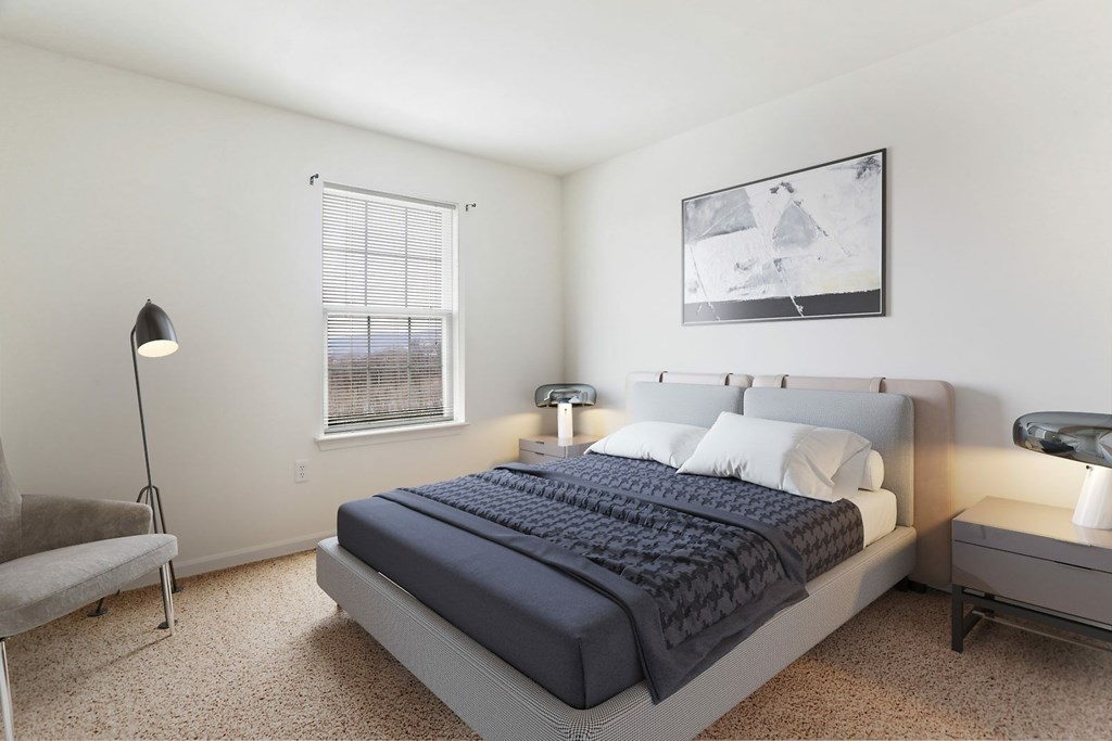 A bedroom with a bed, nightstand, and chair.