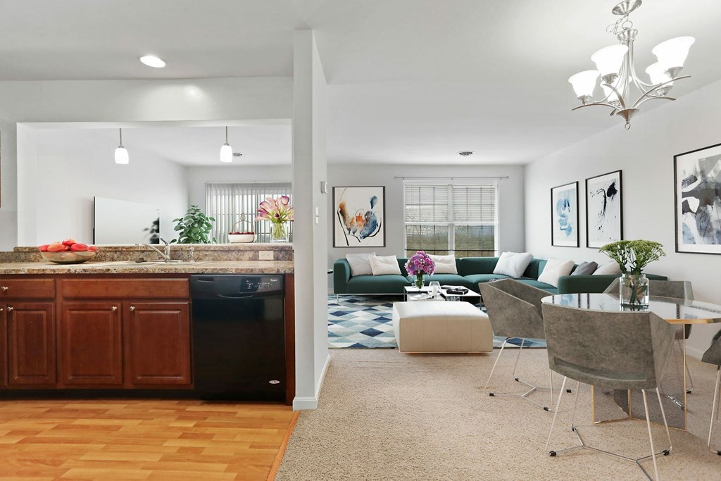 A modern kitchen with a dining area in the background.