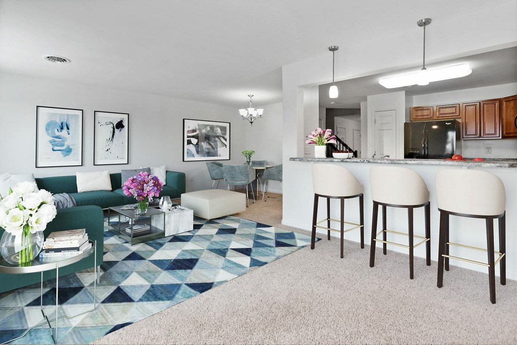 A living room with a green couch and a blue and white rug.