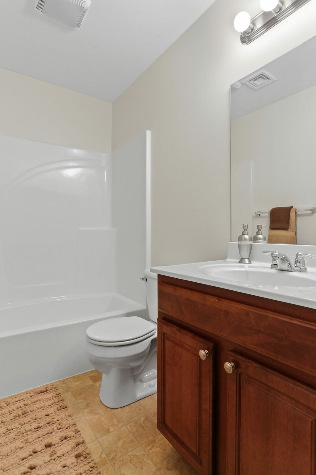 A white toilet sits in a bathroom with wooden cabinets.