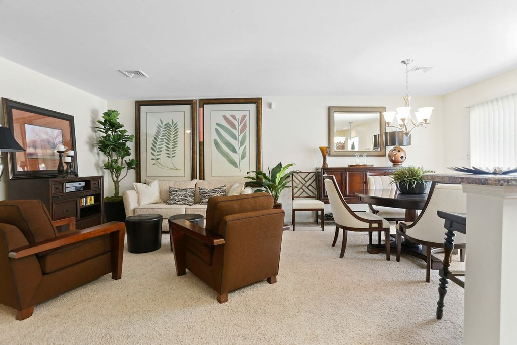 A living room with a brown couch and a white chair.
