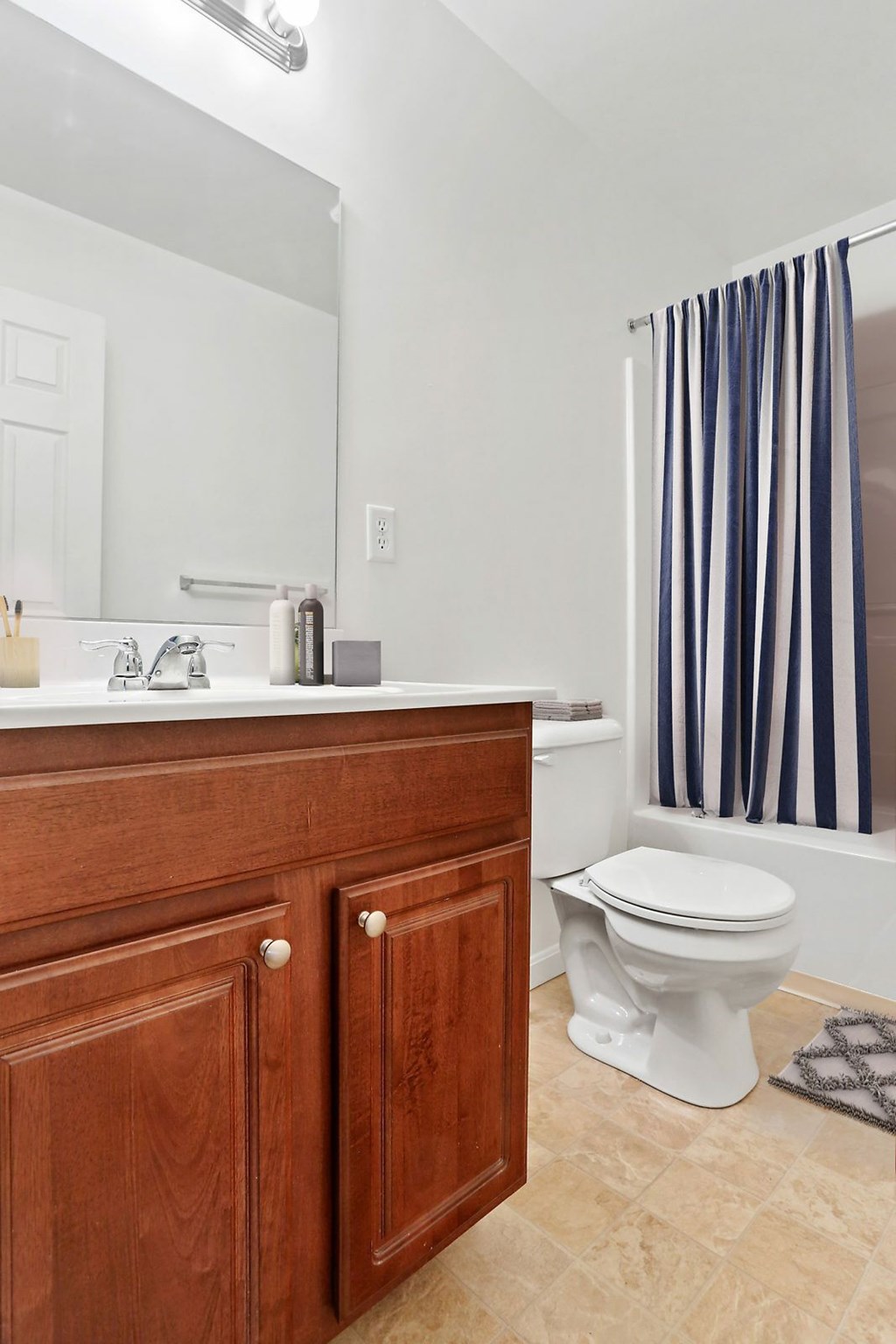 A white toilet sits in a bathroom next to a wooden cabinet.