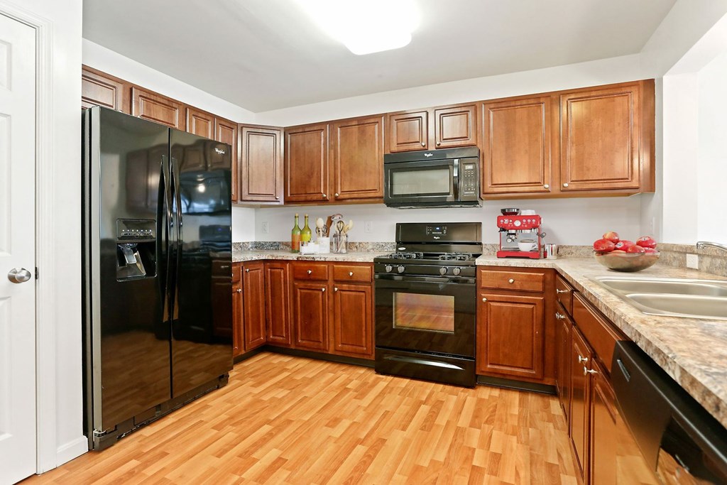 A kitchen with wooden cabinets and a black stove top oven.