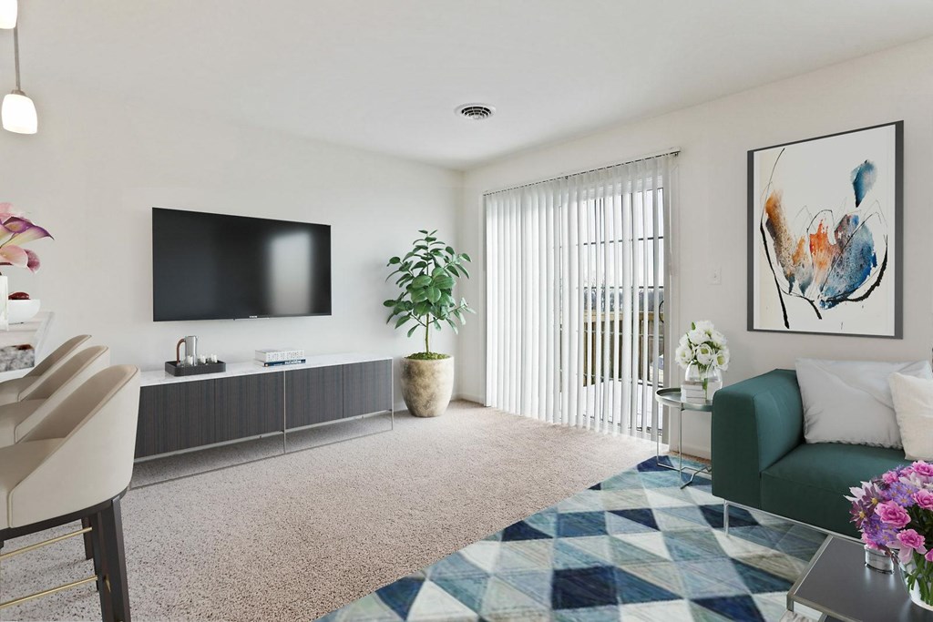A living room with a green couch, a flat screen TV, and a painting on the wall.