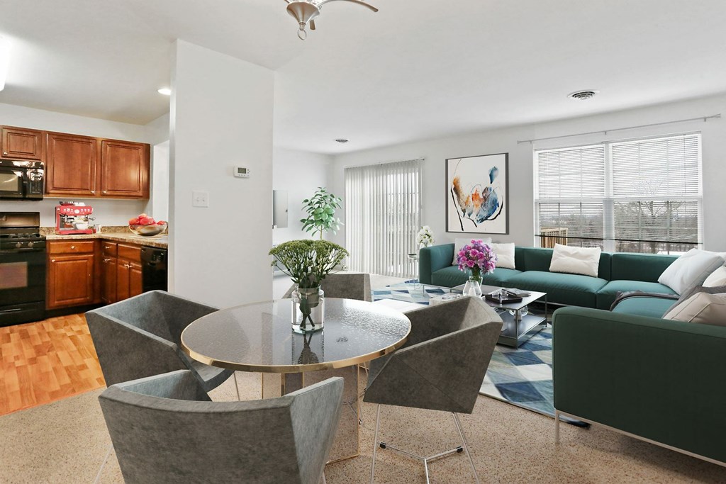 A modern dining room with a glass table and grey chairs.