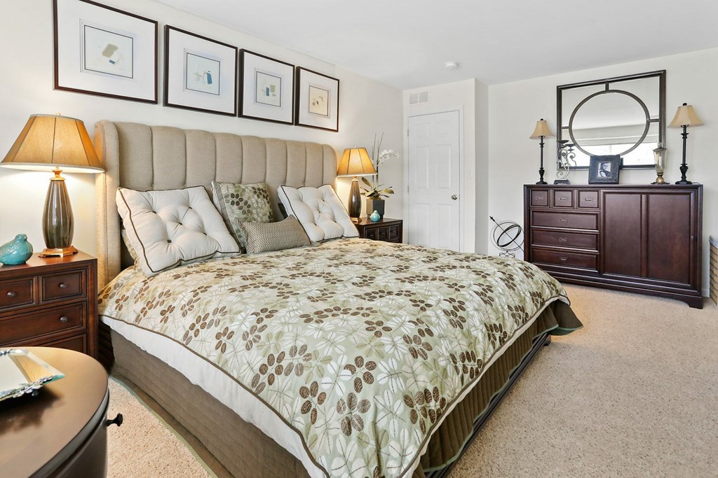 A bedroom with a large bed and a dresser.