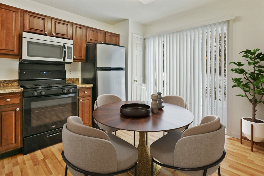 A kitchen with a table and chairs.
