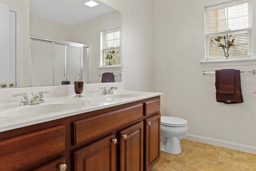 A bathroom with a white counter top and a white toilet.