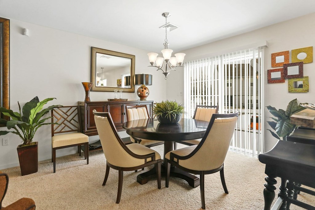 A dining room with a table and chairs.