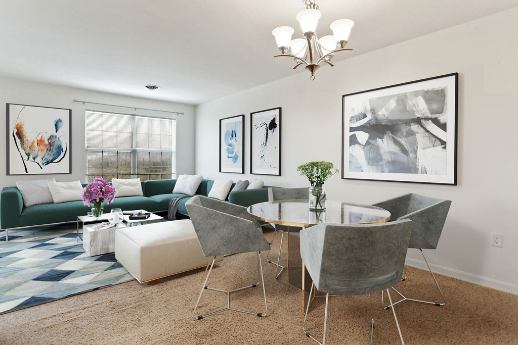 A living room with a green couch, a coffee table, and a chandelier.
