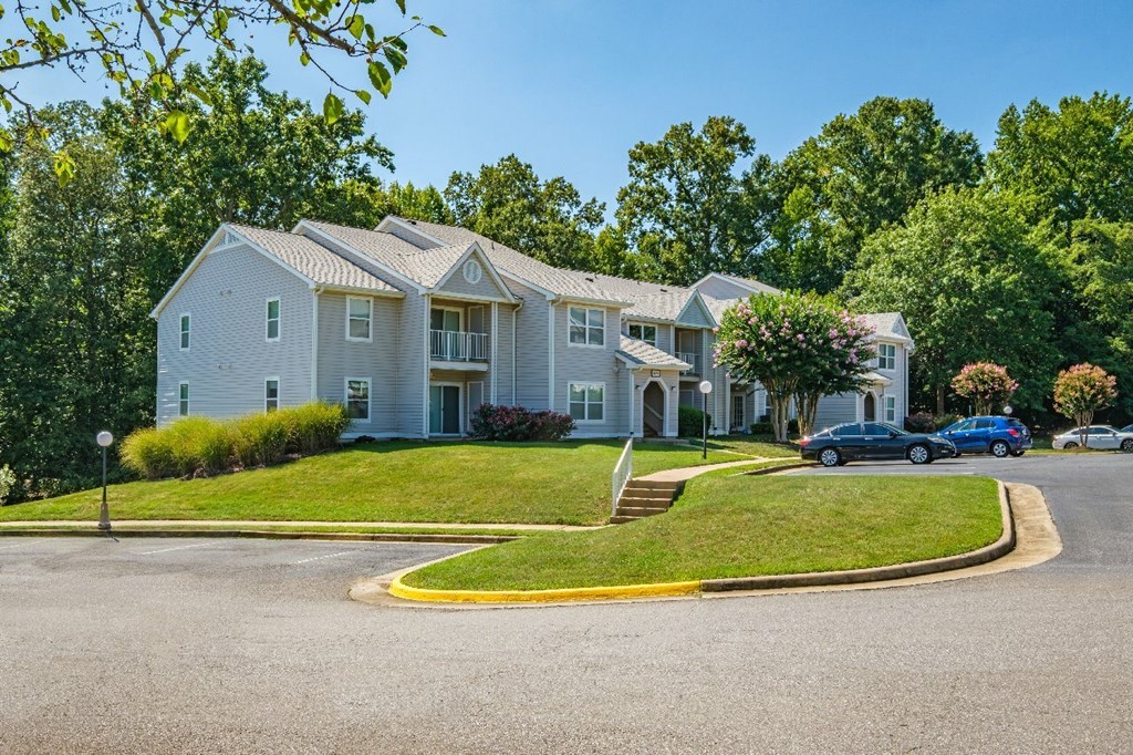 A large white building with a green lawn in front.