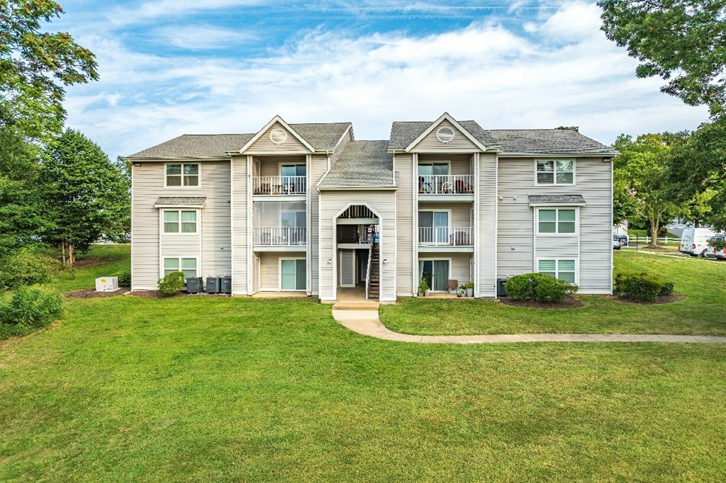 A large, two-story residential building with a balcony on the second floor.