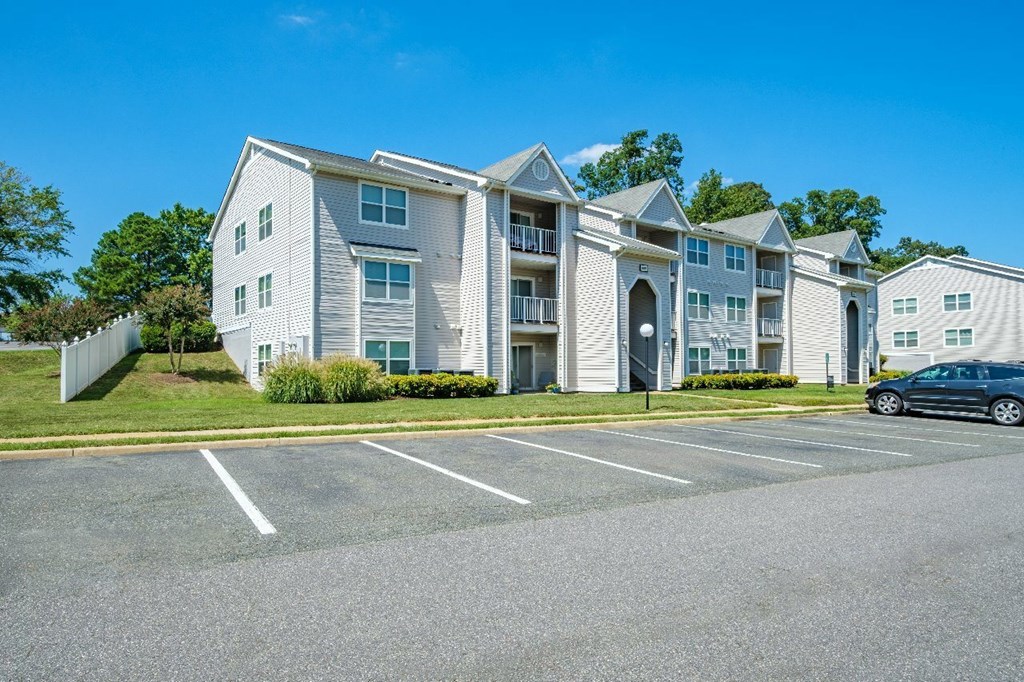 A large white building with a parking lot in front.