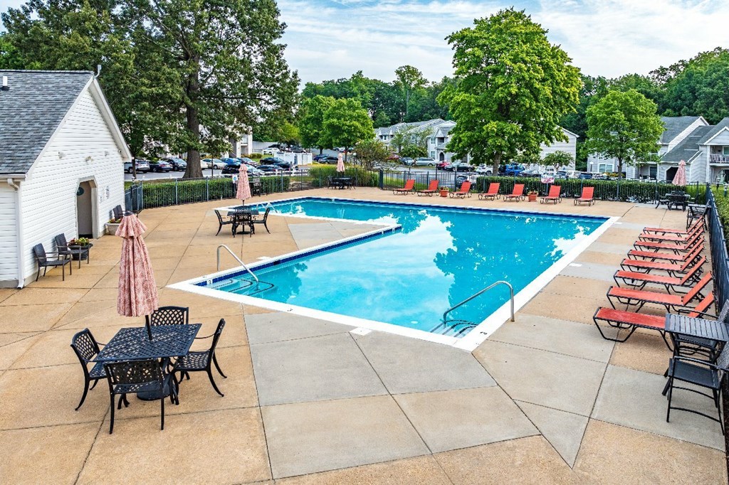 A pool with a table and chairs around it.