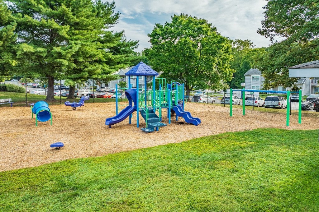 A playground with a blue slide and green play equipment.