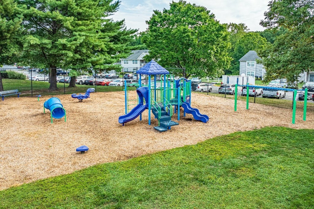 A playground with a blue and green slide and a blue canopy.