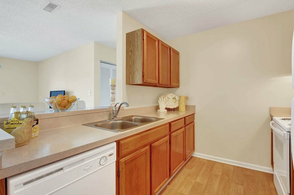 A kitchen with wooden cabinets and white appliances.