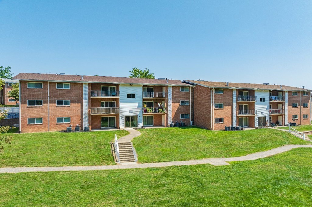 Apartment complex with a grassy area in front.