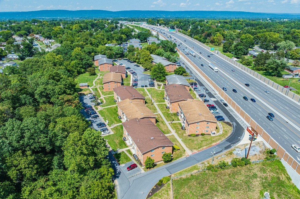 A road with cars and houses on the side.