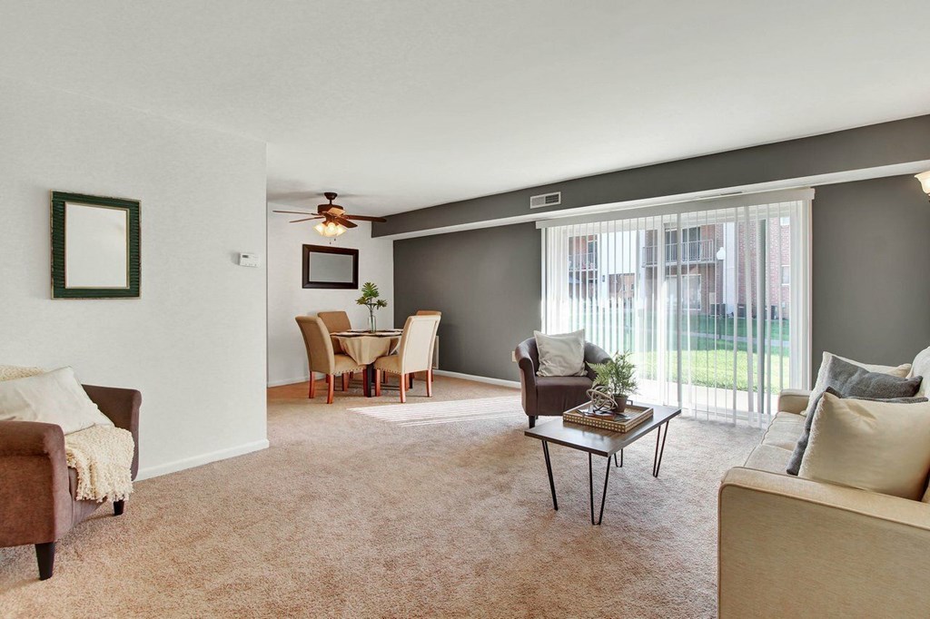 A living room with a brown chair and a brown couch.