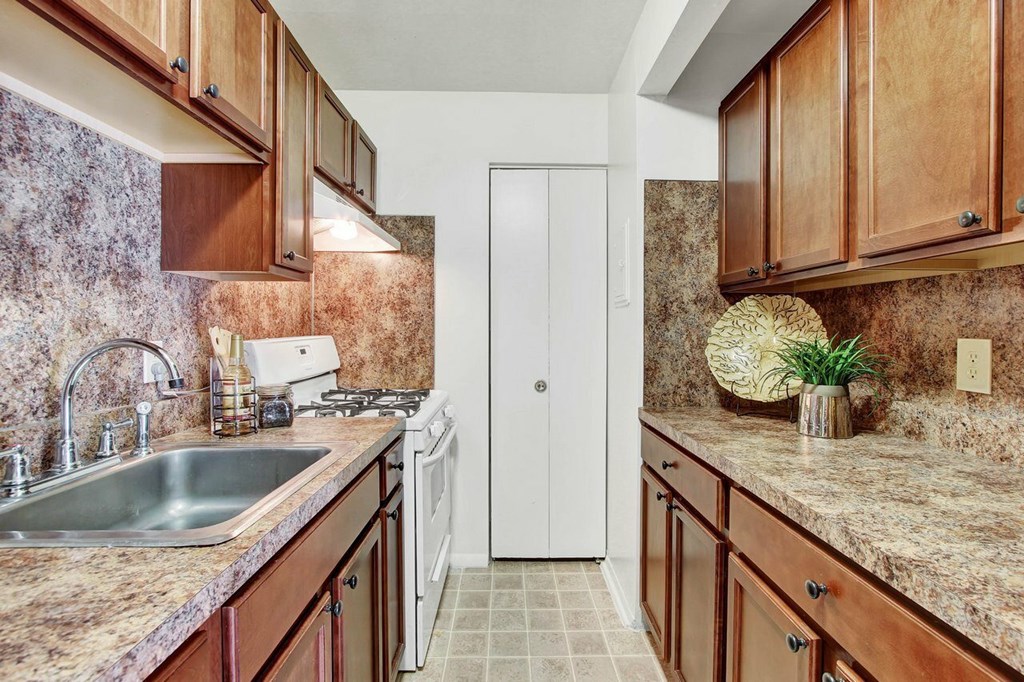 A kitchen with brown cabinets and a white door.