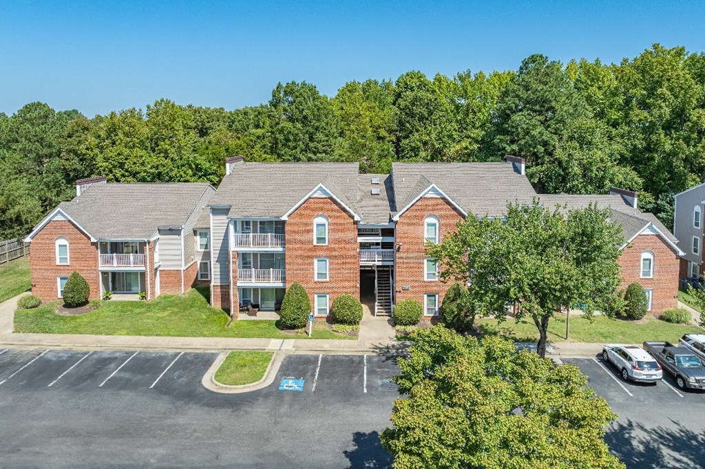 A large red brick building with a parking lot in front.