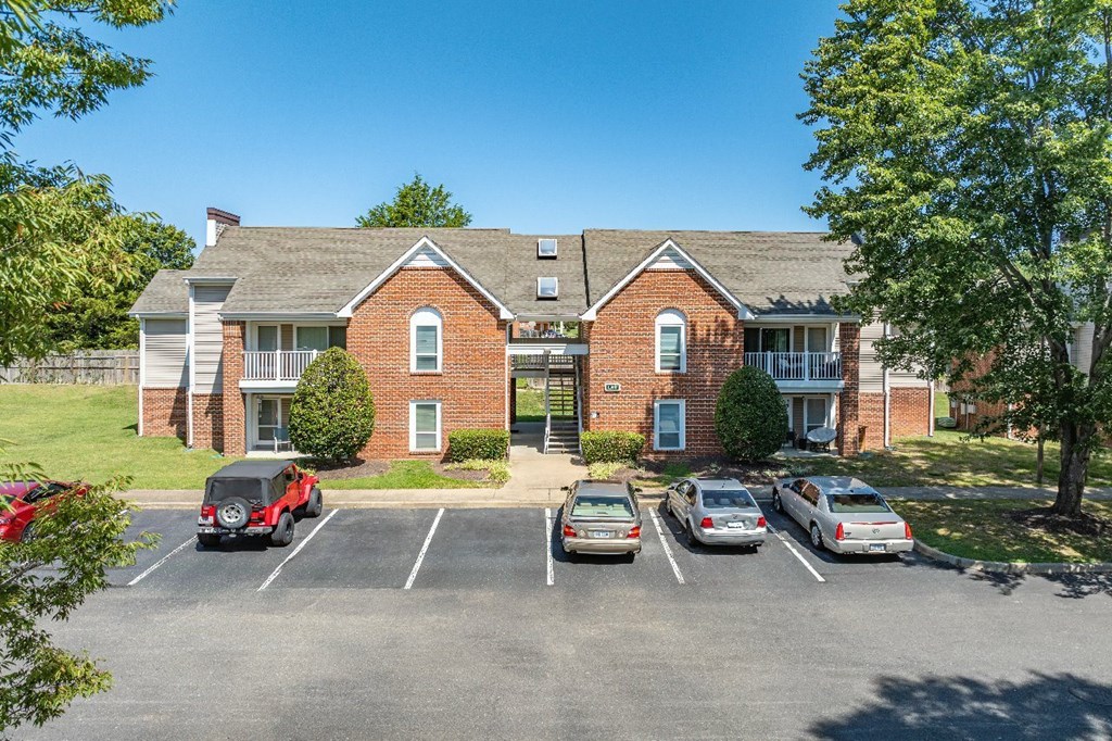 A parking lot with cars and a building in the background.
