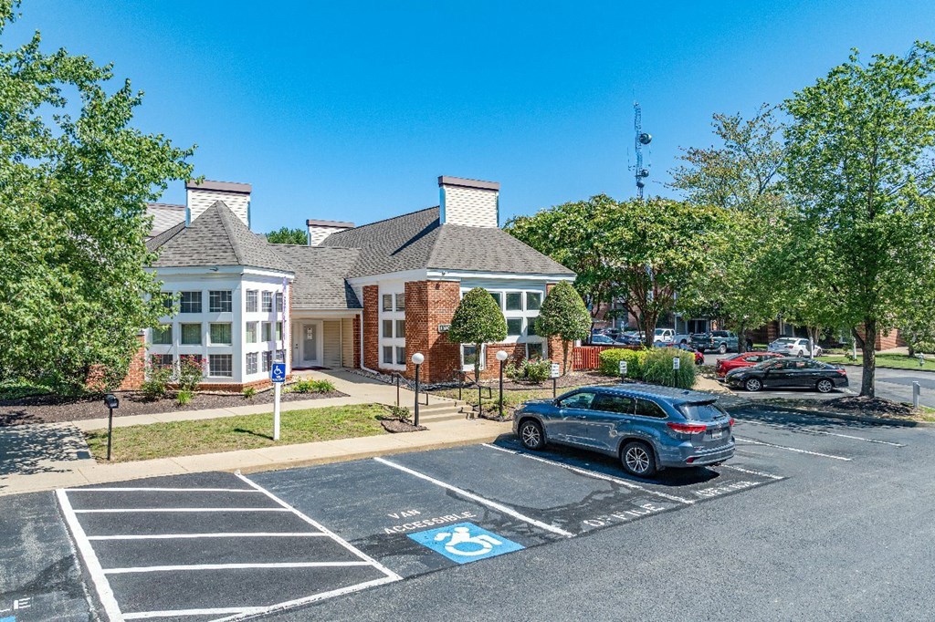 A parking lot with a car parked in the handicapped spot.