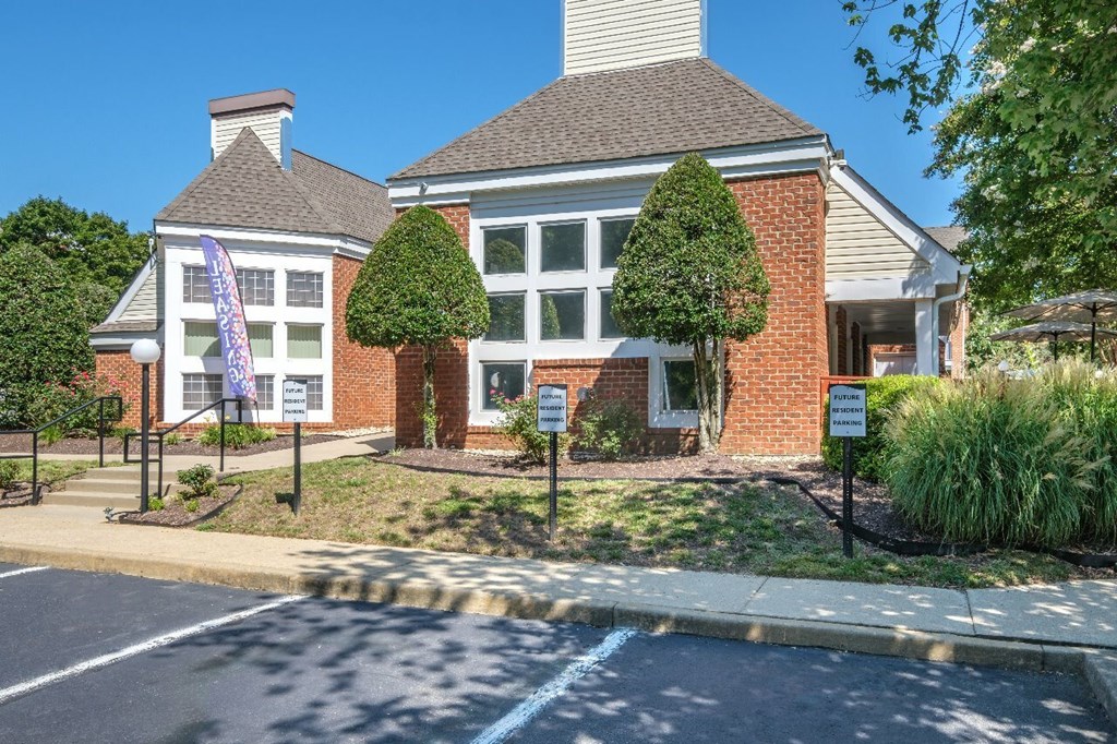 A brick building with a white trim and a sign in front of it.