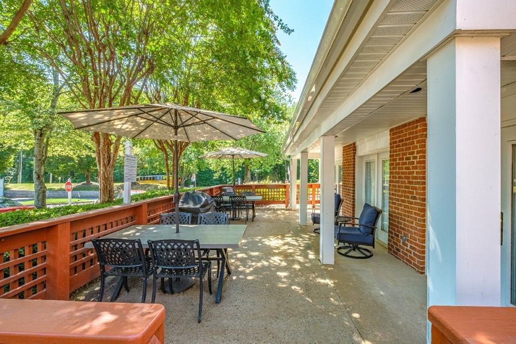 A patio with a table and chairs under an umbrella.
