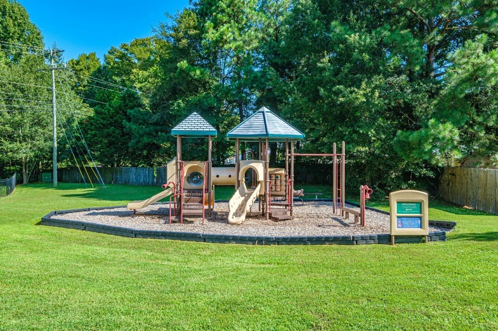 A playground with a slide, swings, and a roundabout.