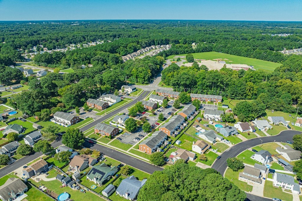 A bird's eye view of a residential neighborhood with houses, roads, and greenery.