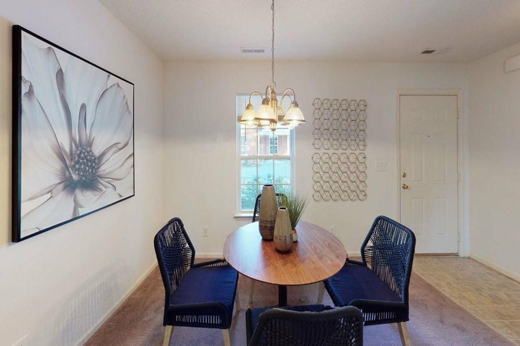 A dining room with a round table and chairs.