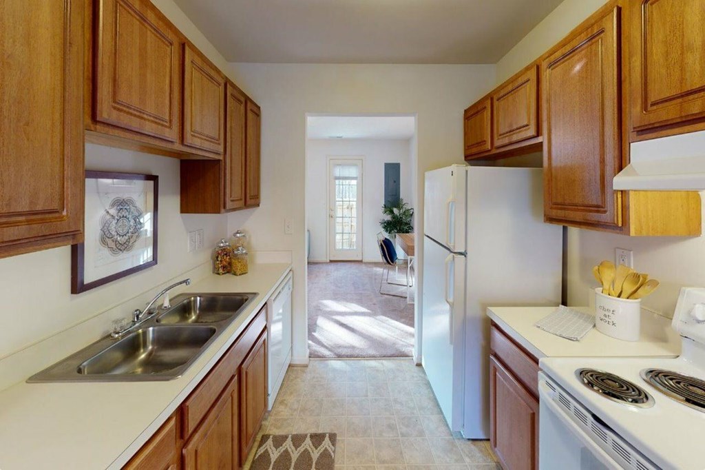 A kitchen with wooden cabinets and a white fridge.