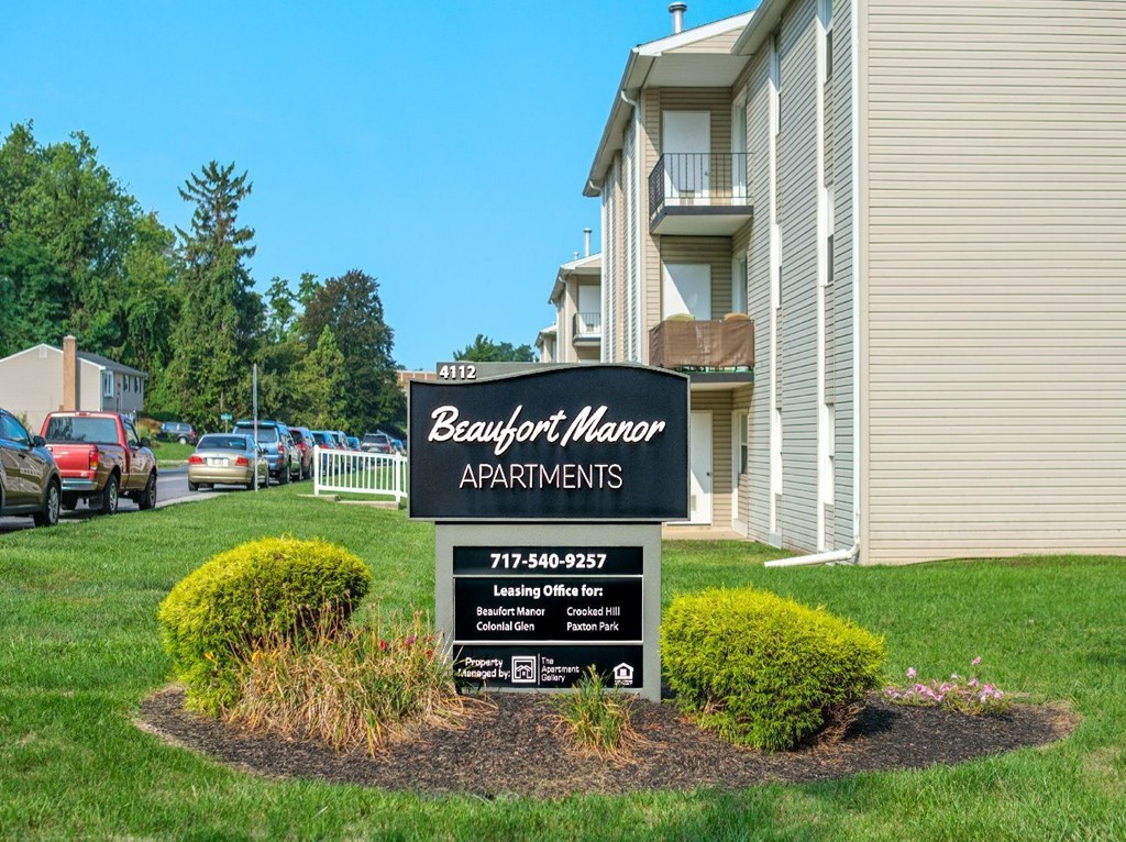 A Beallion Manor Apartments sign sits in front of a building.