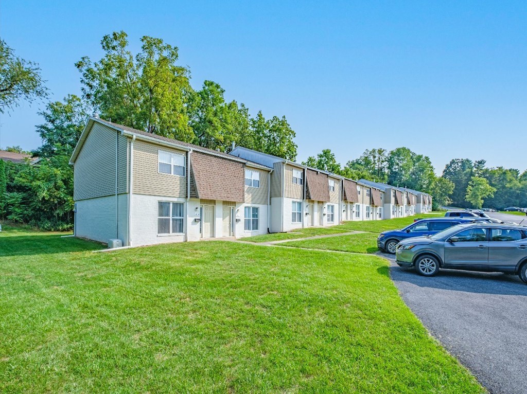 A row of houses with a car parked in front of them.