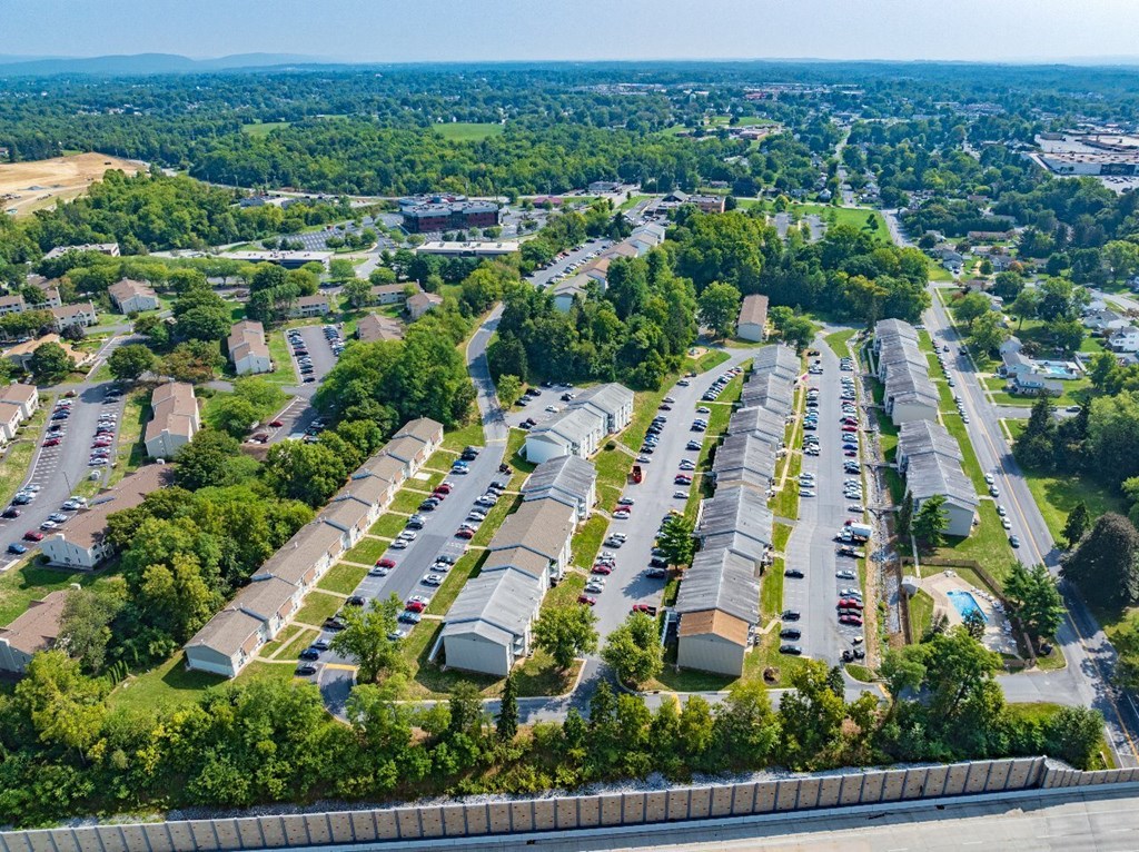 A large parking lot with multiple rows of parked cars.