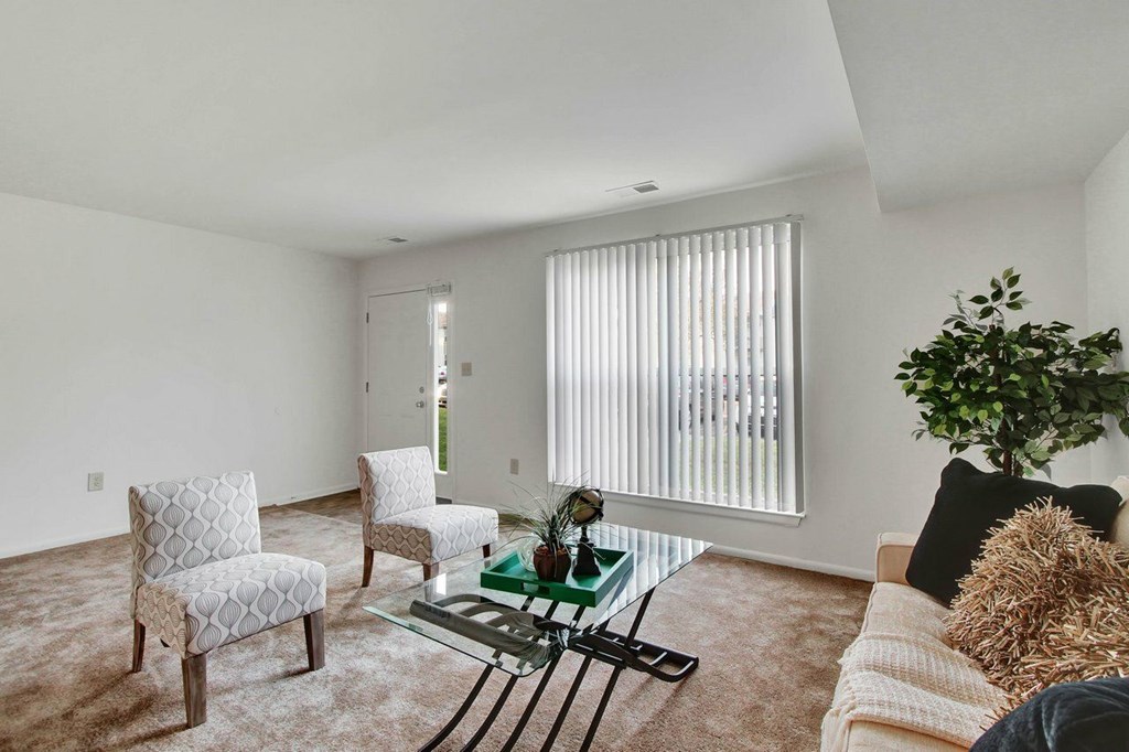 A living room with a couch, two chairs, and a coffee table.