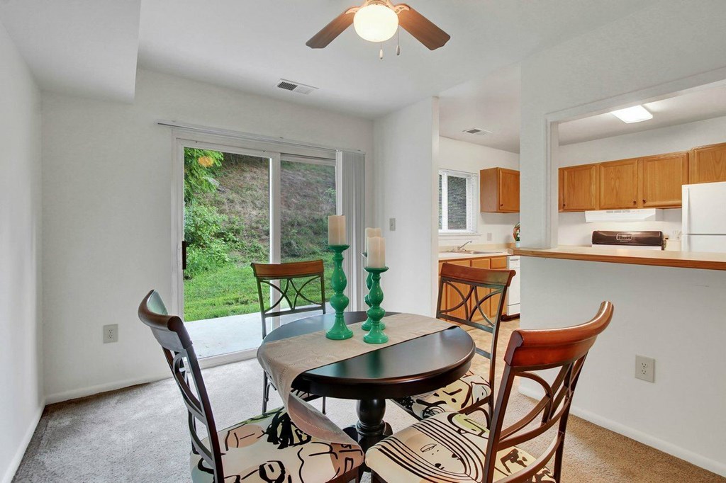 A dining room with a table and chairs.