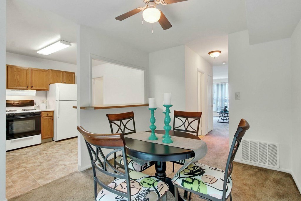 A dining room with a table and chairs.