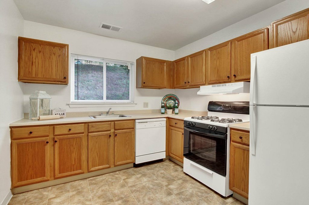 A kitchen with wooden cabinets and white appliances.