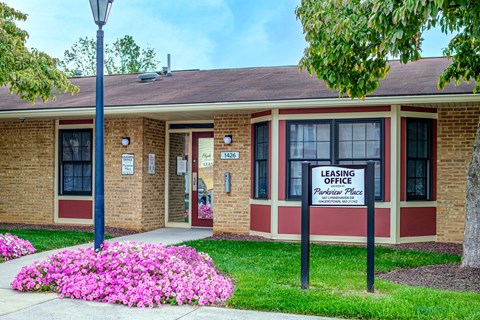 A brick building with a sign that says "Leasing Office" in front of it.
