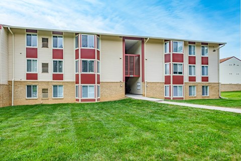A large grassy area in front of apartment buildings.