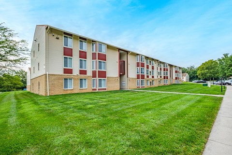 A long building with red and white doors and windows.