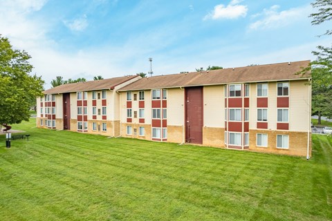A long building with a green lawn in front.