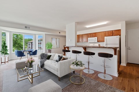 A modern living room with a white couch and a glass coffee table.